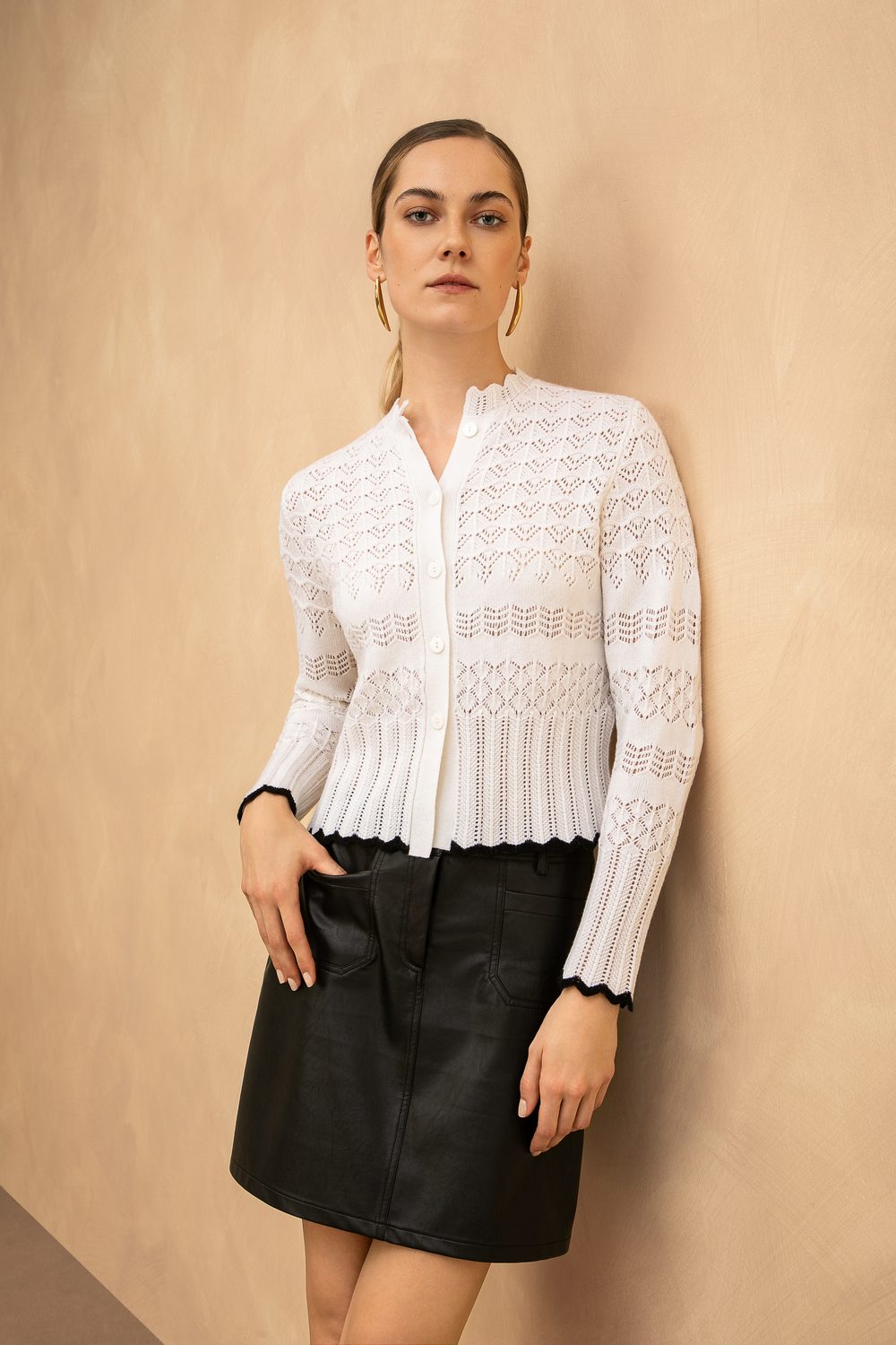 Cardigan traforato bianco su gonna nera, in studio